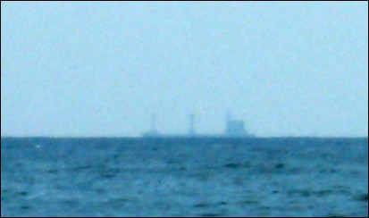 Ship at sea somewhat low on the
                    spherical horizon of Earth